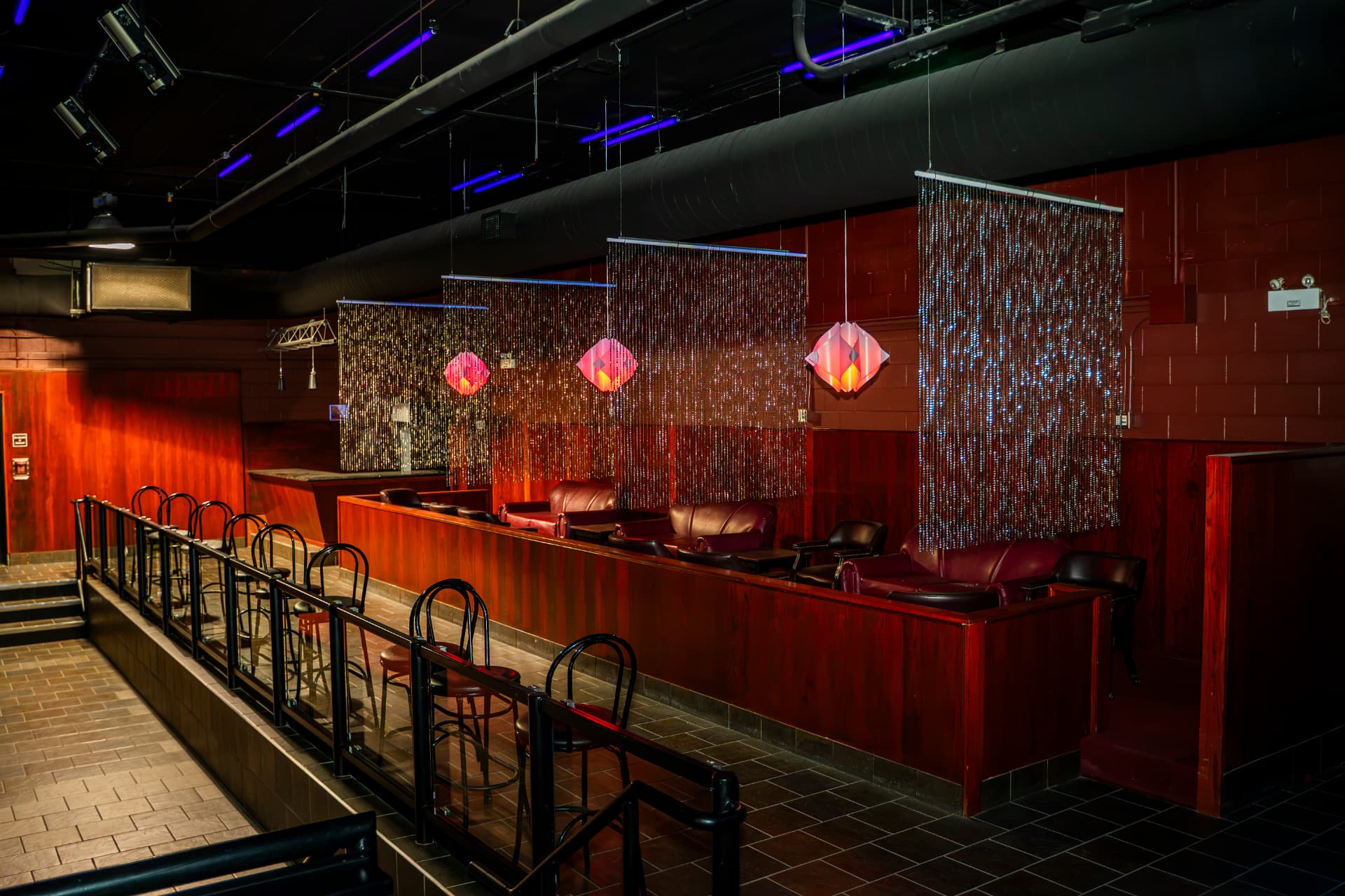 Private lounge booths with leather seating and shimmering curtains at Cactus Jaxx